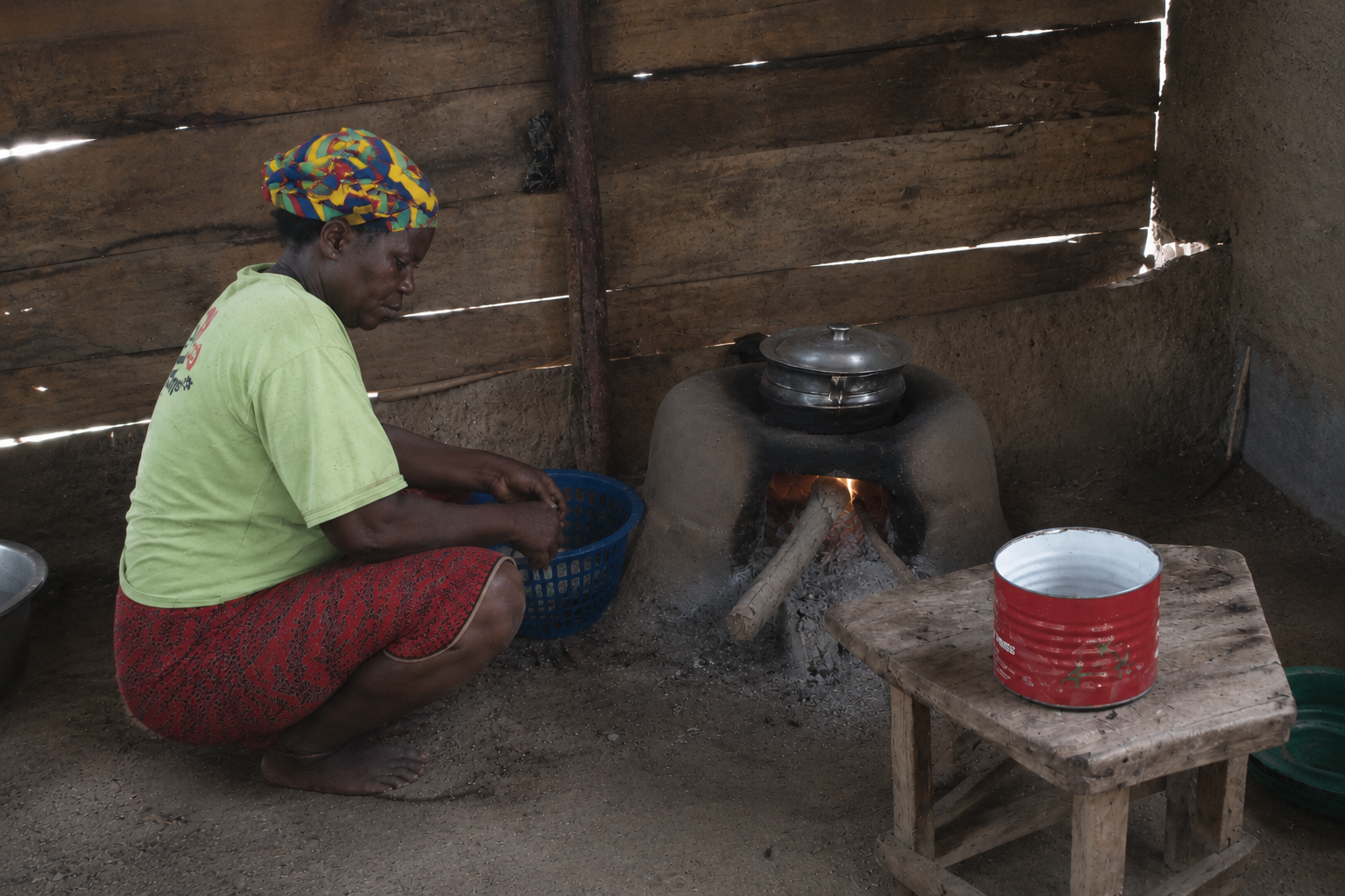 Why Now / Energy — smoke from a wood/charcoal cooking fire in a kitchen.